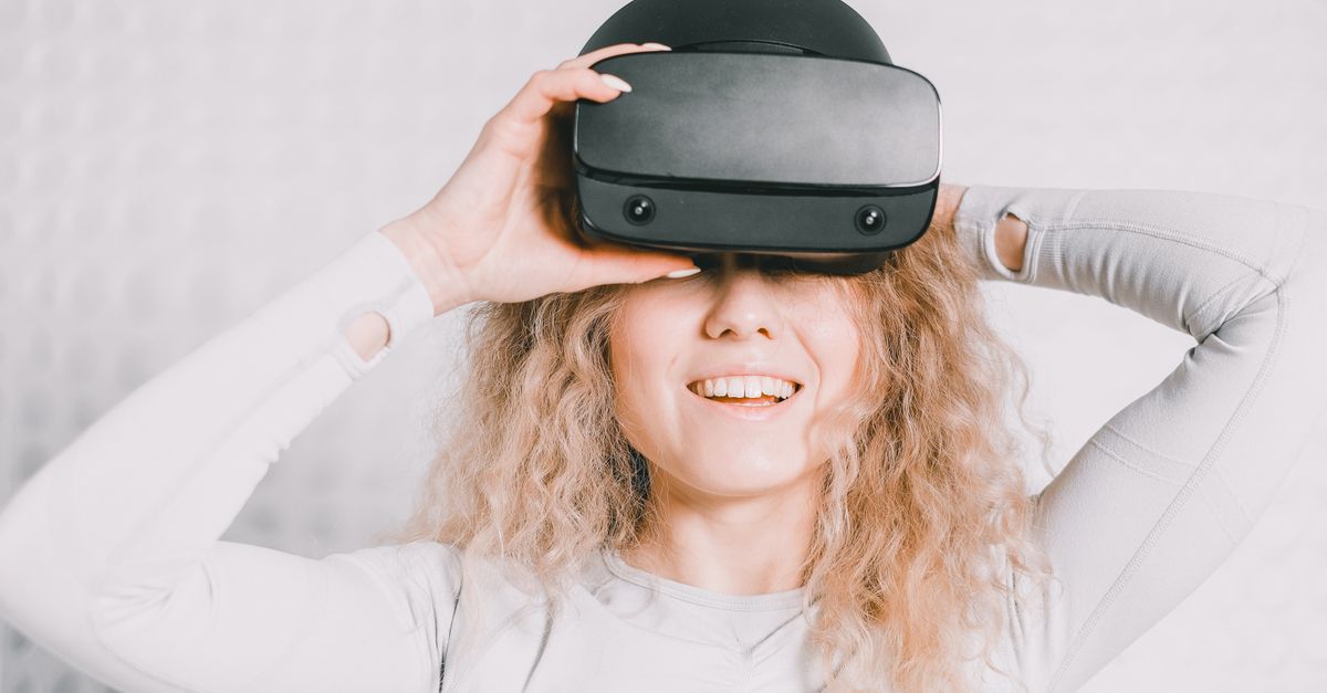 Smiling woman wearing a VR headset and experiencing virtual reality excitement.